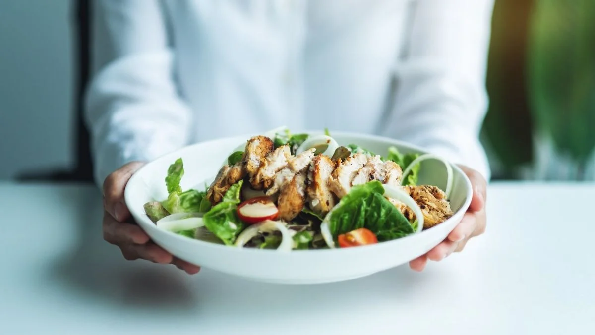 Ein Bild mit einer Schüssel mit Salat und gebratenem Fleisch