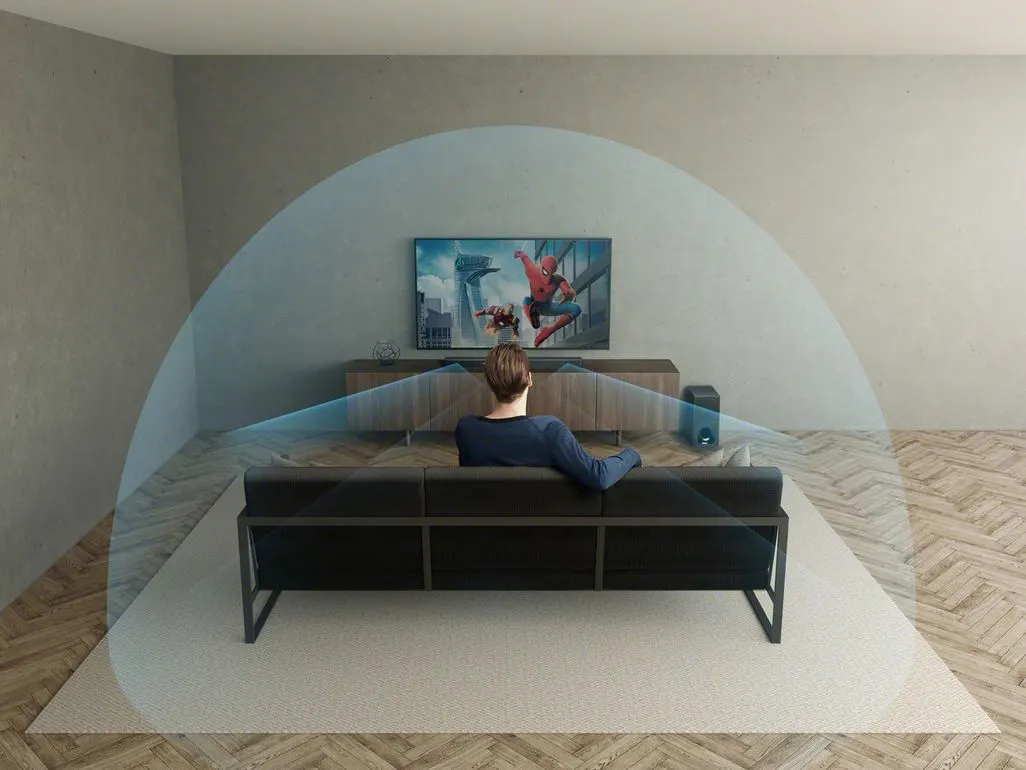 Person sitzt auf Sofa vor Fernseher mit visualisiertem Raumklang.