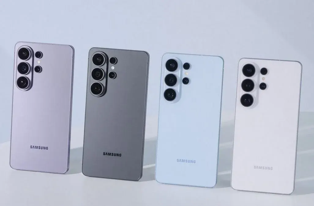 Vier Samsung‑Smartphones in Pastellfarben (lila, grau, hellblau, weiß) stehen nebeneinander; Rückseiten mit Kameramodulen sichtbar.