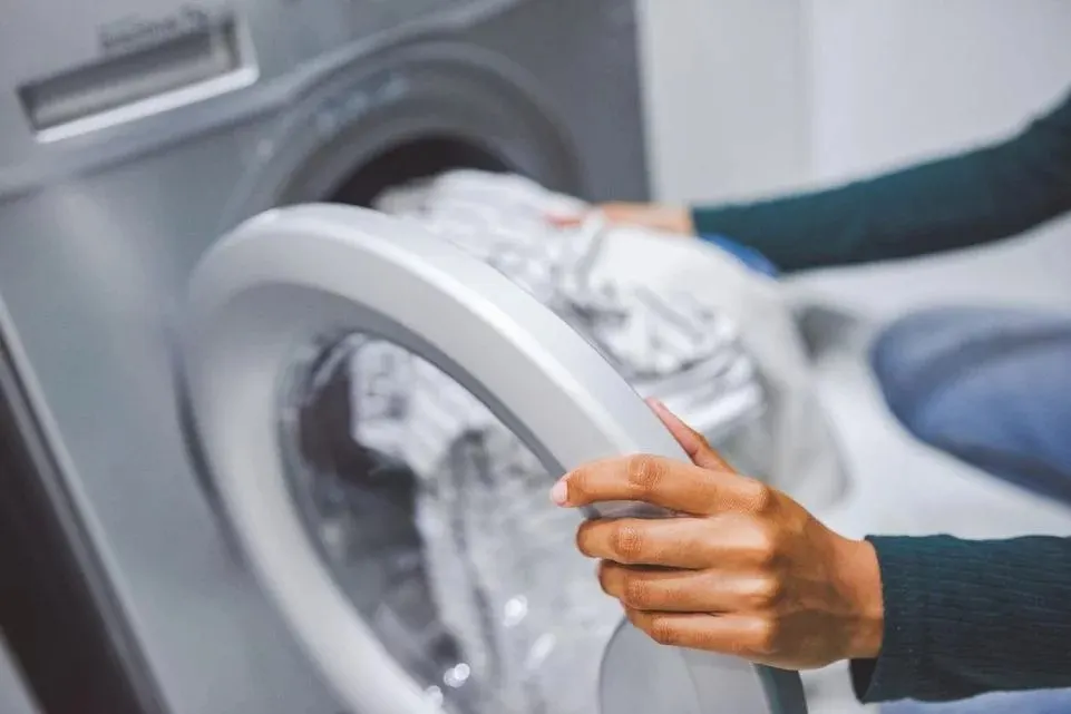Waschmaschine wird mit heller Wäsche befüllt
