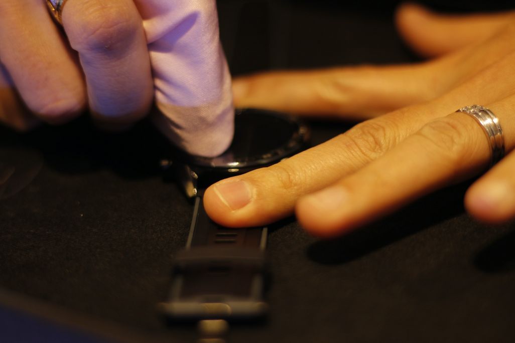 Eine Person mit poliert das Display einer Smartwatch.