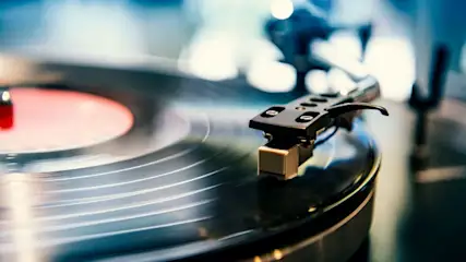 Nahaufnahme eines Plattenspielers mit aufgelegter Schallplatte und Tonabnehmer