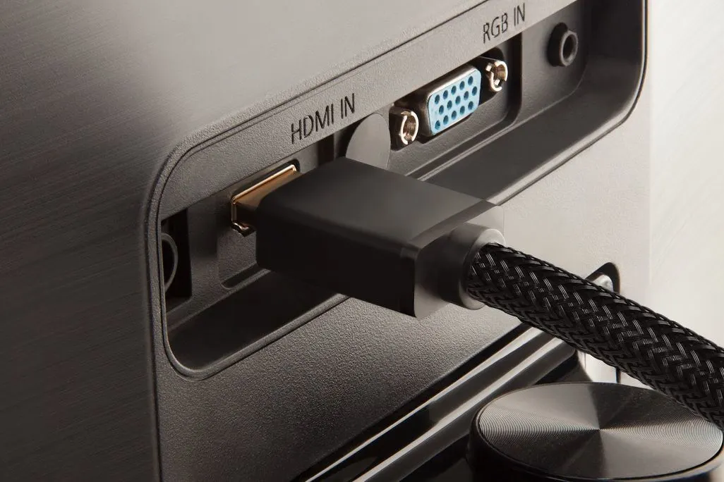 Nahaufnahme eines HDMI-Kabels das in einen Fernseher eingesteckt wird.