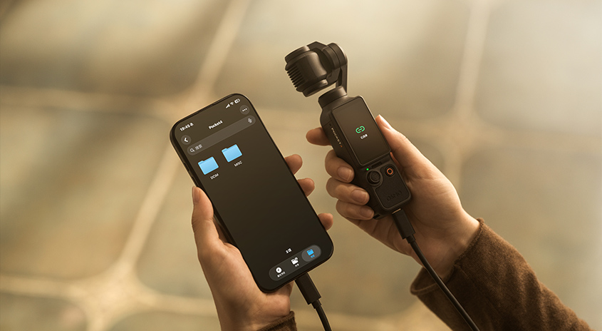 Hände halten Smartphone mit Kontroll-App und DJI Osmo Pocket 3 Kamera-Gimbal. Verbundene Geräte für professionelle Videoaufnahmen.