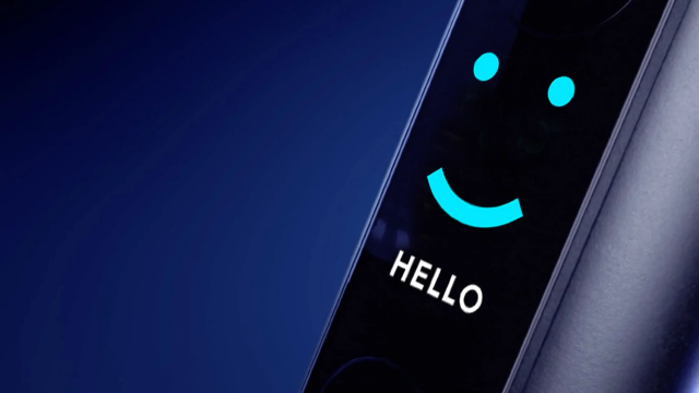 Auf blauem Hintergrund zeigt ein Gerät ein digitales, blaues Smiley-Gesicht und den Text "HELLO" in weißer Schrift.