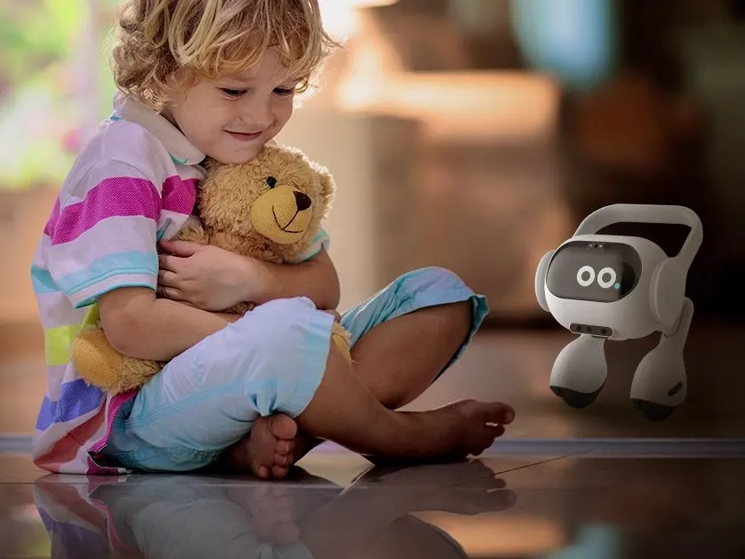 Kind in gestreiftem Shirt umarmt Teddybär auf glänzendem Boden. Ein weißer Roboter mit runden Augen steht daneben.