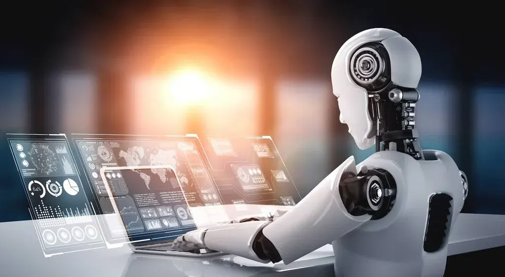 Weißer Roboter mit schwarzen Gelenken sitzt am Tisch und bedient Hologram-Displays mit Datenvisualisierungen vor verschwommenem Büro-Hintergrund.