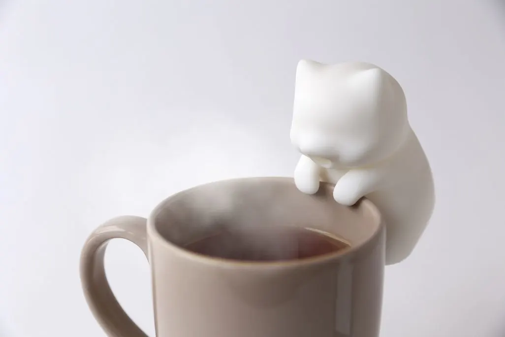 Mini-Ventilator in Katzenform an einer Tasse, der auf Getraenk pustet bis es abkuehlt