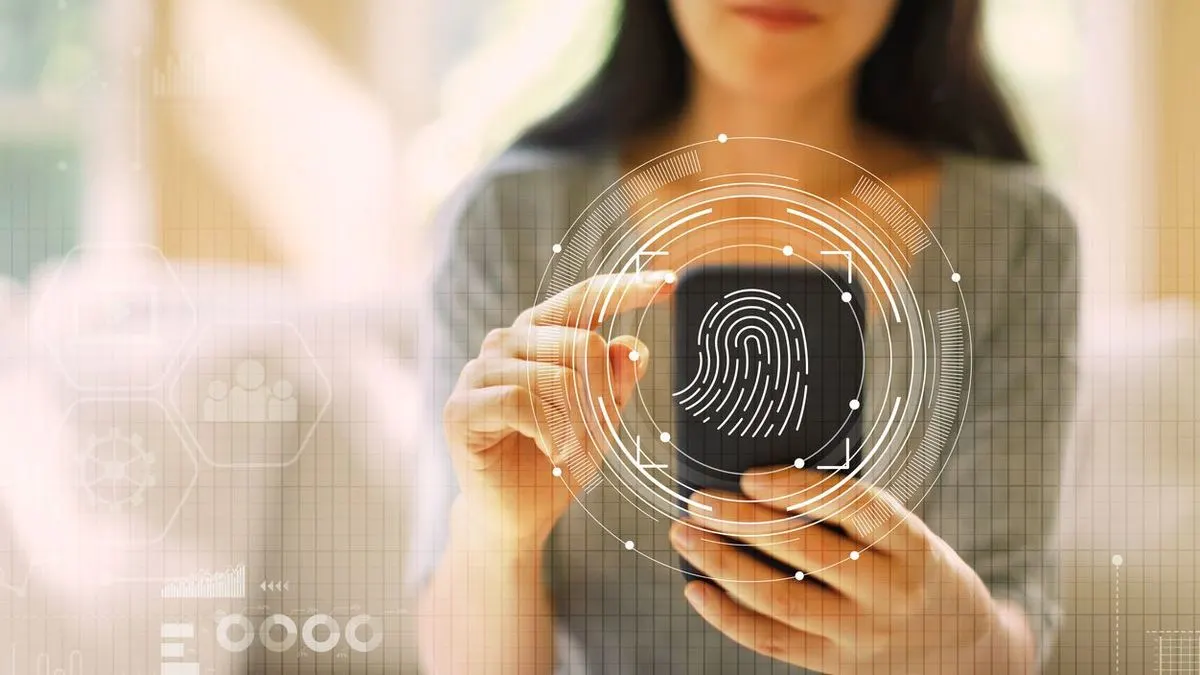 Frau entsperrt ein Smartphone mit Fingerabdruckscanner - digitale Symbole deuten dies an