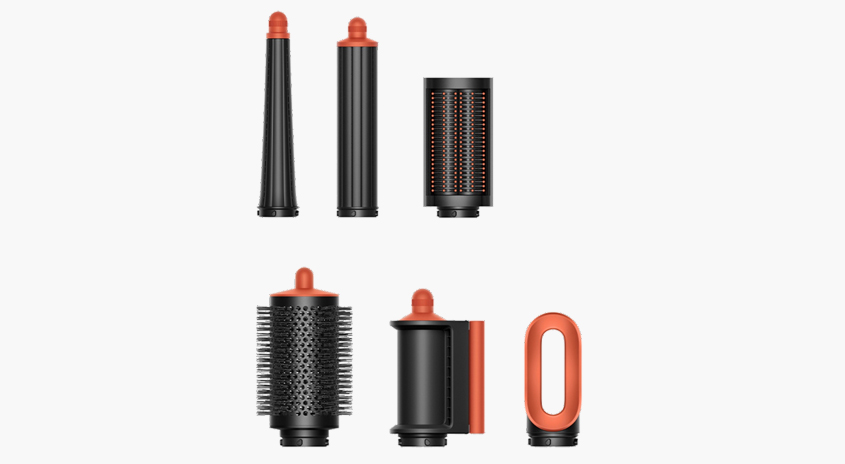Sechs Aufsätze für den Dyson Airwrap, schwarz mit orangen Akzenten, vor einem reinweißen Hintergrund.