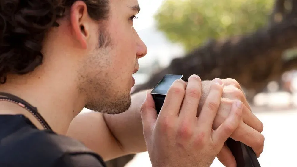 Mann spricht in seine Smartwatch am Handgelenk