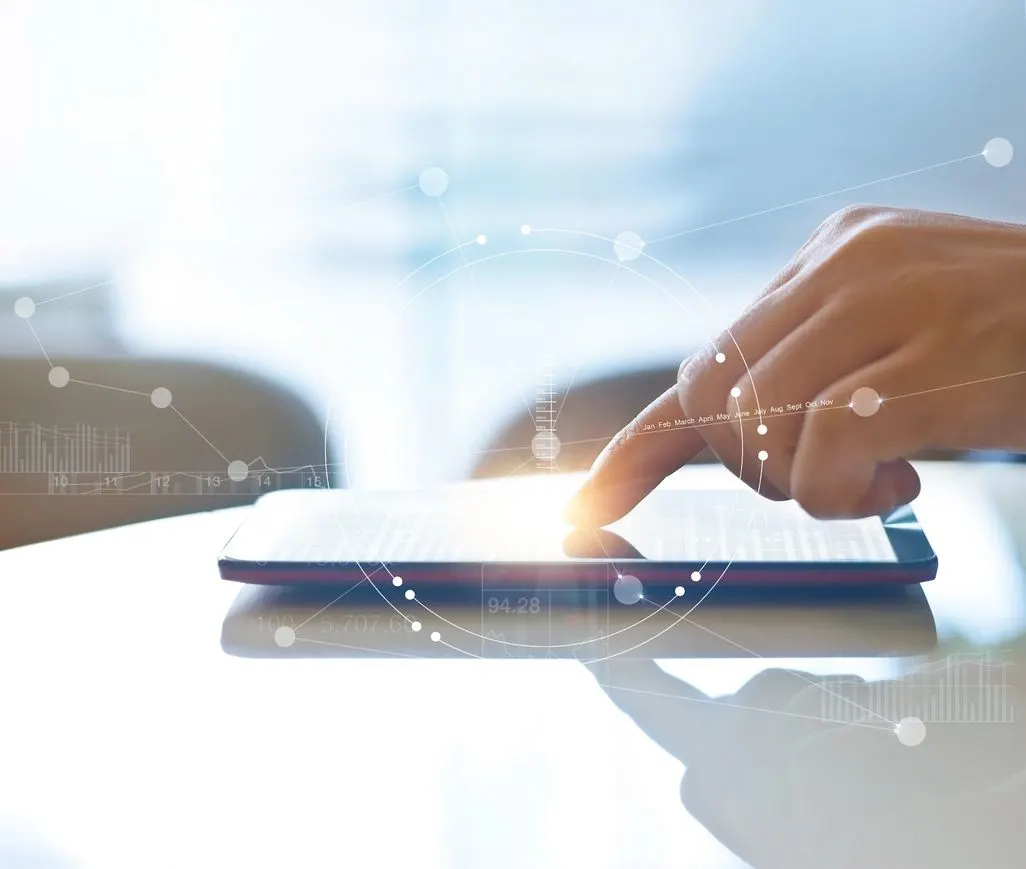 Eine Hand bedient ein Tablet auf einem Tisch.