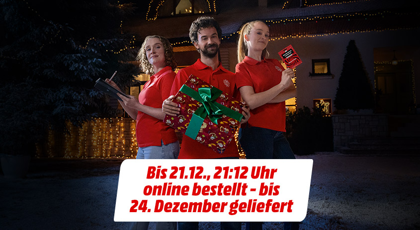 Drei junge Menschen vor einem weihnachtlich geschmückten Haus. Sie halten ein Geschenk bzw. einen MediaMarkt Service Gutschein in der Hand. Text im Bild: Bis 21.12., 21:12 Uhr online bestellt - bis 24. Dezember geliefert.