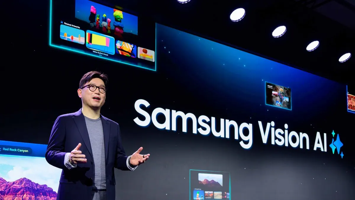 Person steht auf einer Bühne vor einer großen Leinwand mit der Aufschrift Samsung Vision AI und präsentiert.