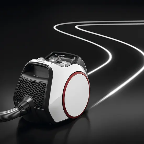 Ein weißer Staubsauger mit rotem Akzent steht auf schwarzem Untergrund. Lichtstreifen ziehen sich kurvenreich durch den Hintergrund.