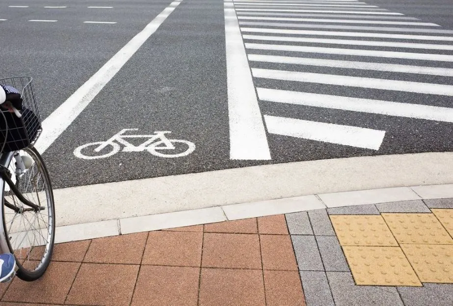 Fahrradweg mit Markierung an einer Kreuzung und einem Zebrastreifen