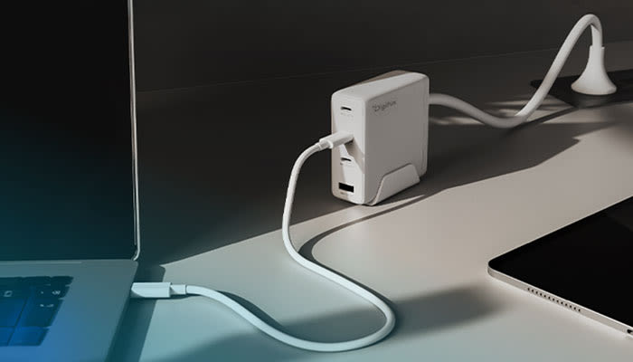 Weißes Digitus Multi-Port-Ladegerät mit Standfuß auf einem Schreibtisch, das einen Laptop auflädt.