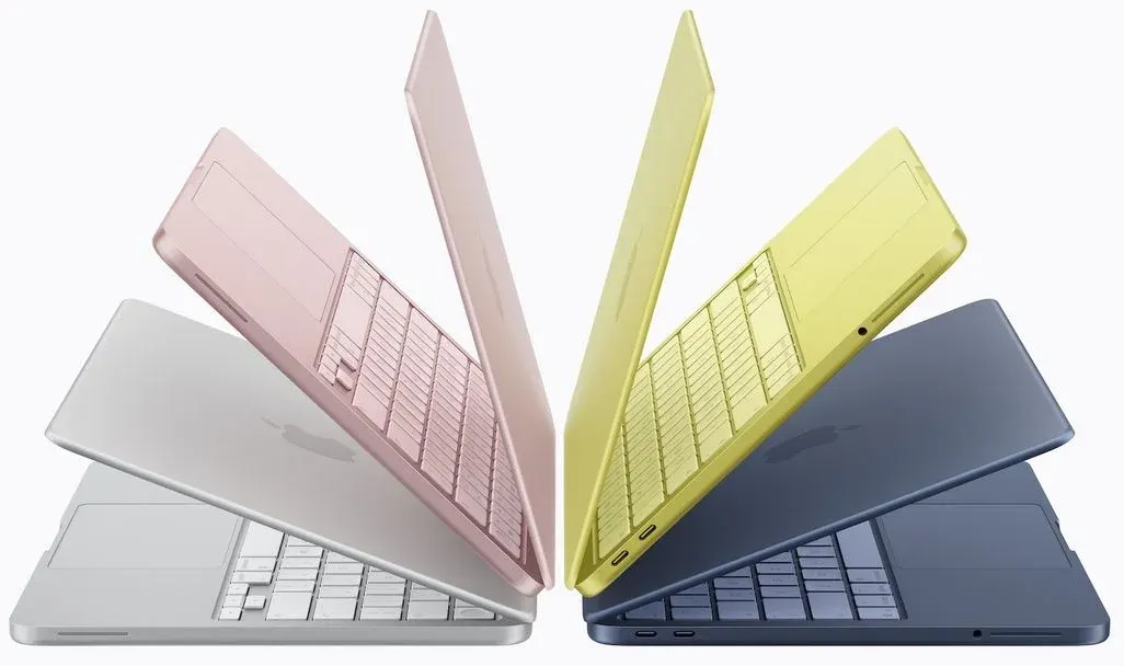 Vier MacBook Neo-Geräte in den aktuellen Farben sind fächerartig in einem Halbkreis angeordnet.