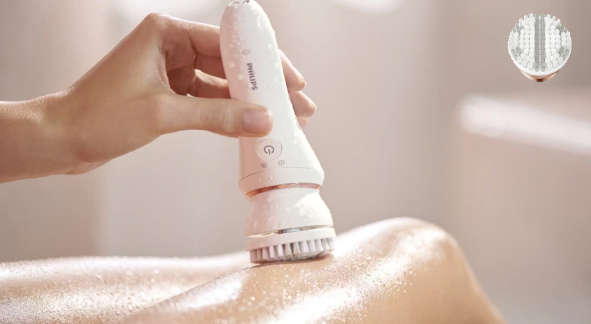 Eine Hand hält ein weißes Philips-Gerät mit Bürste an einem Körperteil, vermutlich Rücken oder Schulter.