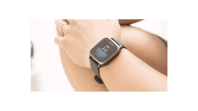 Nahaufnahme einer Smartwatch am Handgelenk mit blauen Wellen auf dem Bildschirm.