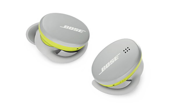 Zwei graue Bose-Ohrhörer mit gelben Akzenten liegen auf einem weißen Hintergrund.