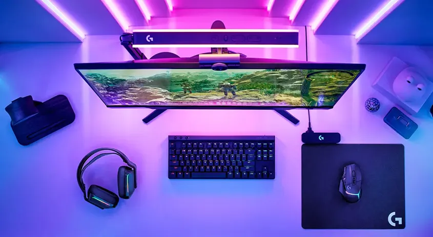 Ein Schreibtisch mit einem Monitor, einer Tastatur, einer Maus, einem Mauspad, einem Headset und einer VR-Brille.