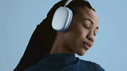 Mann trägt weiße Over-Ear-Kopfhörer mit blauem Hintergrund. Profil-Ansicht, entspannter Ausdruck. Moderne kabellose Audio-Technologie für Musik und Sound.