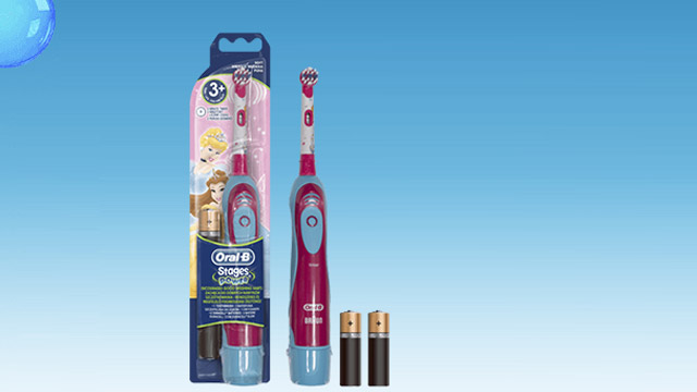 Elektrische Oral-B-Zahnbürste für Kinder mit zwei Batterien vor blauem Hintergrund.
