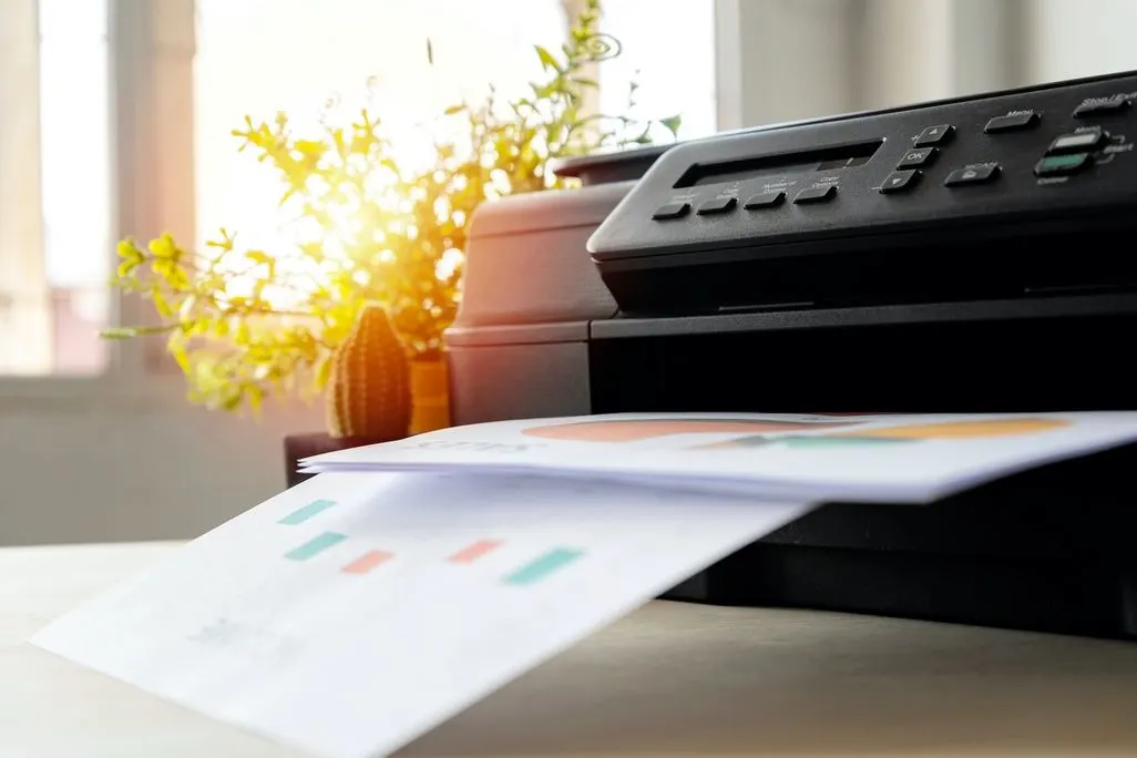 Ein Multifunktionsdrucker druckt Dokumente mit bunten Diagrammen aus.