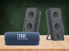 Zwei kabellose Lautsprecher stehen auf einem Holztisch.