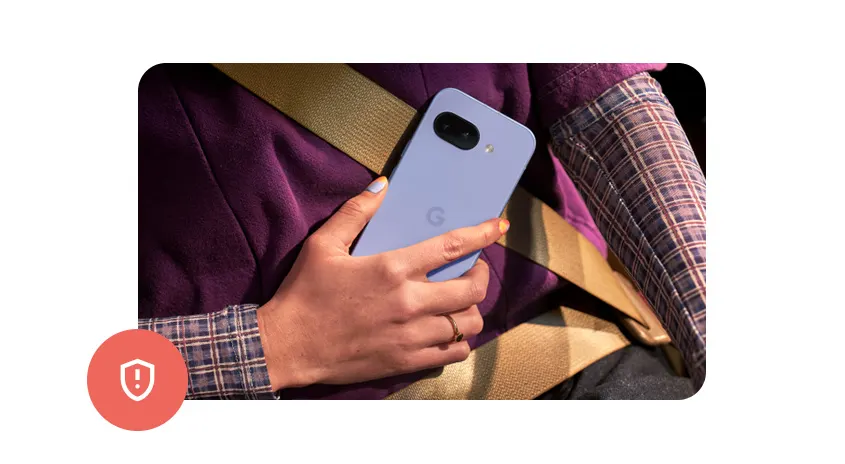 Eine Person hält ein lila Smartphone vor einem Sicherheitsgurt. Die Person trägt ein kariertes Hemd.