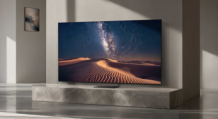 Moderner Fernseher auf marmornem TV-Board zeigt Wüstenlandschaft mit Milchstraße am nächtlichen Himmel