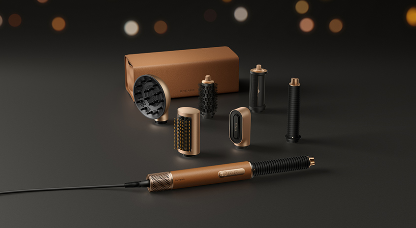 Multifunktionales Haarstyling-Set in Braun und Gold mit verschiedenen Aufsätzen in brauner Verpackung auf dunklem Hintergrund mit bokeh-Lichtern.