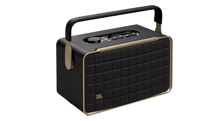 Ein schwarzer Lautsprecher mit Griff und goldenen Akzenten auf einem weißen Hintergrund.