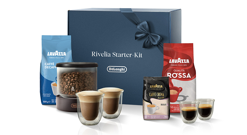 Kaffeepackungen und Tassen, ein Behälter mit Kaffeebohnen und eine blaue Delonghi Rivelia Starter-Kit-Box.