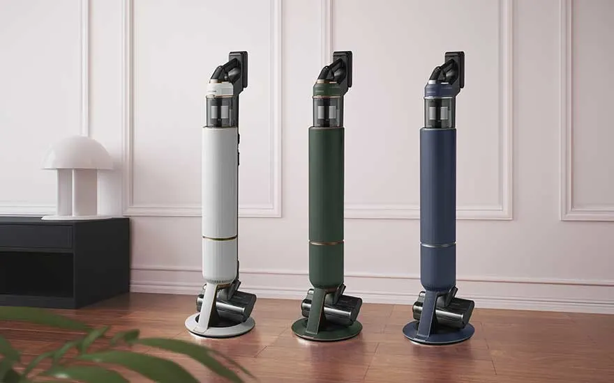 Trois aspirateurs balais haut de gamme sur socle rond, en blanc, vert et bleu, illustrent des couleurs chic pour intérieurs modernes.