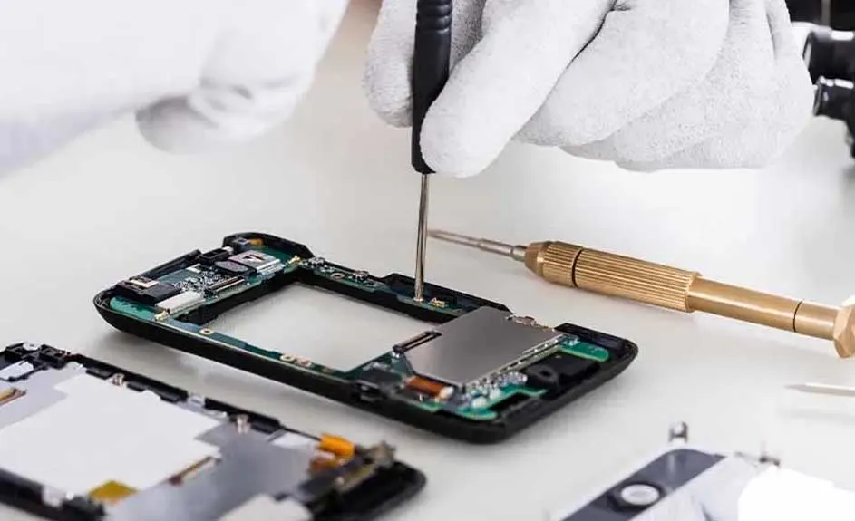 Een opengeslagen smartphone ligt op een witte tafel met een schroevendraaier.