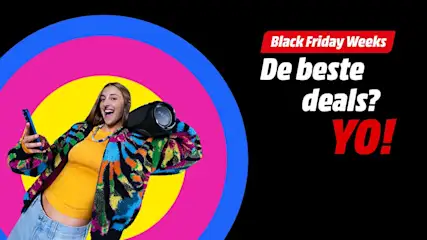 Vrolijke persoon met kleurrijke jas houdt een draagbare speaker op de schouder en een smartphone in de hand, voor felgekleurde cirkels. Tekst rechts: “Black Friday Weeks – De beste deals? YO!” op zwarte achtergrond.