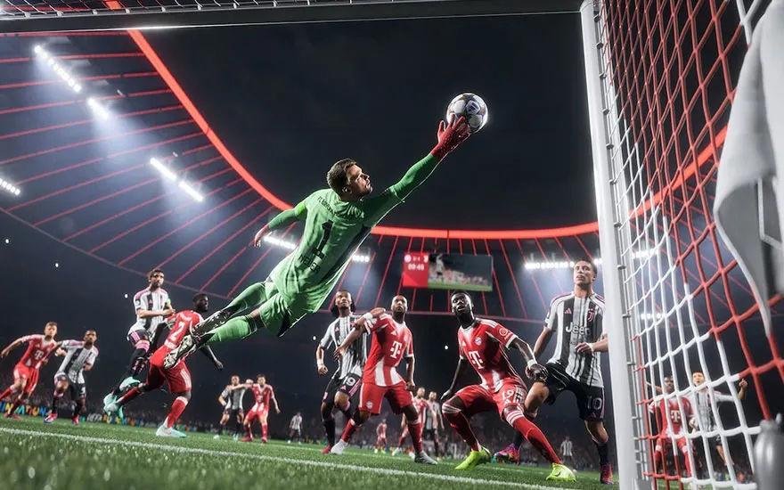 Dramatische keeper redding tijdens voetbalwedstrijd met groene keeper die spectaculair naar de bal duikt in het doel