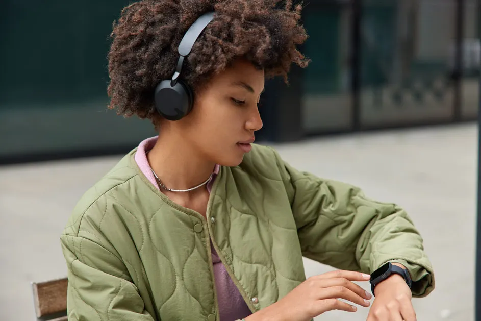 Une veste matelassée vert olive, un casque noir et une montre intelligente sont visibles.