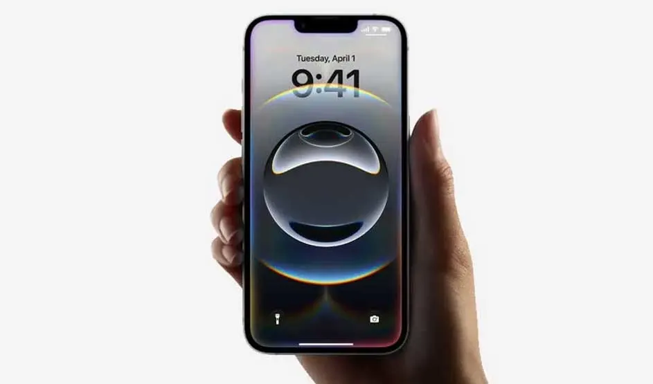 Une main tient un iPhone Apple ; écran verrouillé avec fond abstrait, date et heure bien visibles, design caractéristique d’Apple.