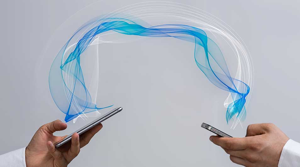 Deux mains tenant des téléphones, liées par des lignes bleues et blanches sur fond gris.