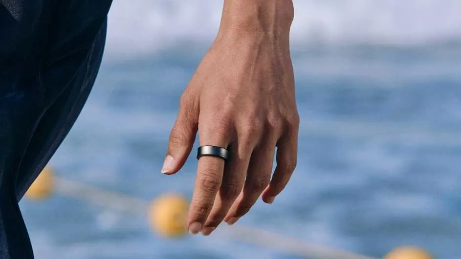 Hand met ring, voor blauw water en gele boeien.