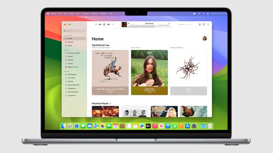 Een zilverkleurige laptop toont een muziekapp met albumhoezen op een kleurrijke achtergrond. Het scherm bevat een menubalk en app-pictogrammen.