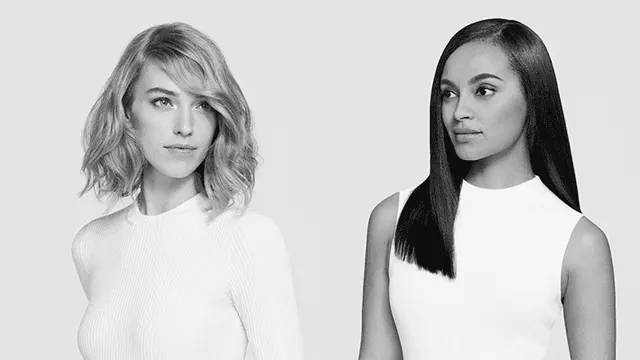 Twee vrouwen in witte tops. Links golvend, kort haar; rechts lang, stijl haar. Grijstinten tegen een lichte achtergrond.