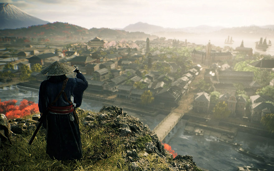 Een vergezicht over een stad met een brug en een berg. Vooraan een rotsachtige heuvel met groene begroeiing.