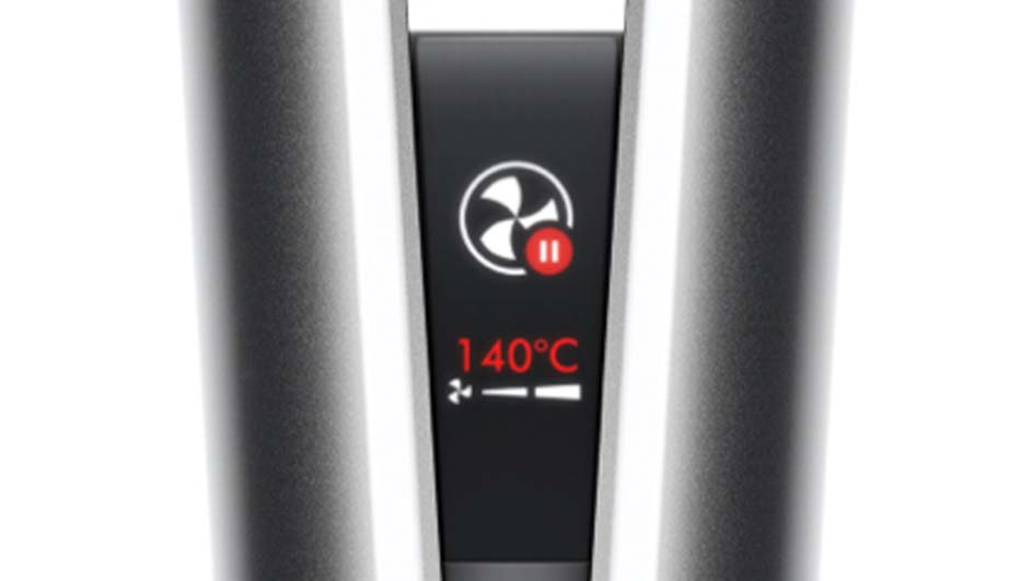 Gros plan d'un appareil avec un écran noir affichant un ventilateur, le texte rouge "140°C" et des barres blanches.