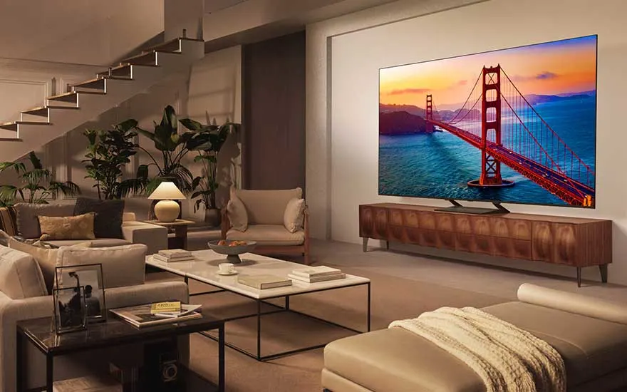 Un salon élégant où un grand téléviseur LG affiche le Golden Gate Bridge, entouré de lumières douces et de nombreuses plantes.