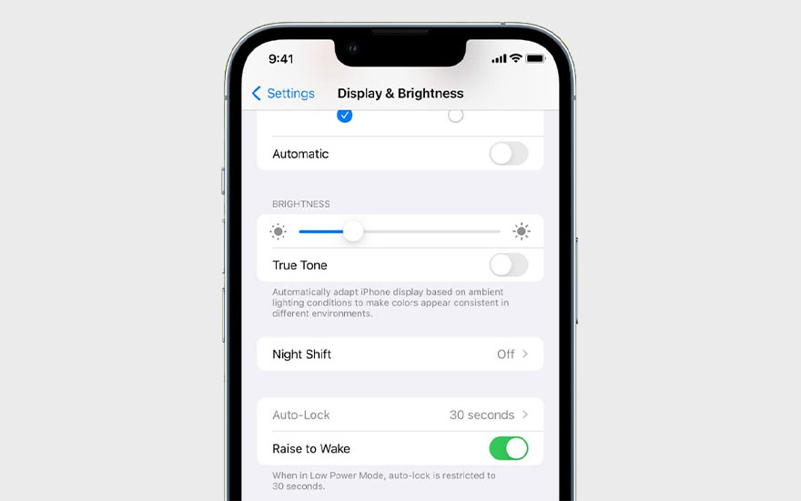 Een iPhone scherm toont 'Display & Helderheid' instellingen met opties zoals Automatisch, Helderheid, True Tone, Night Shift en Auto-Lock.