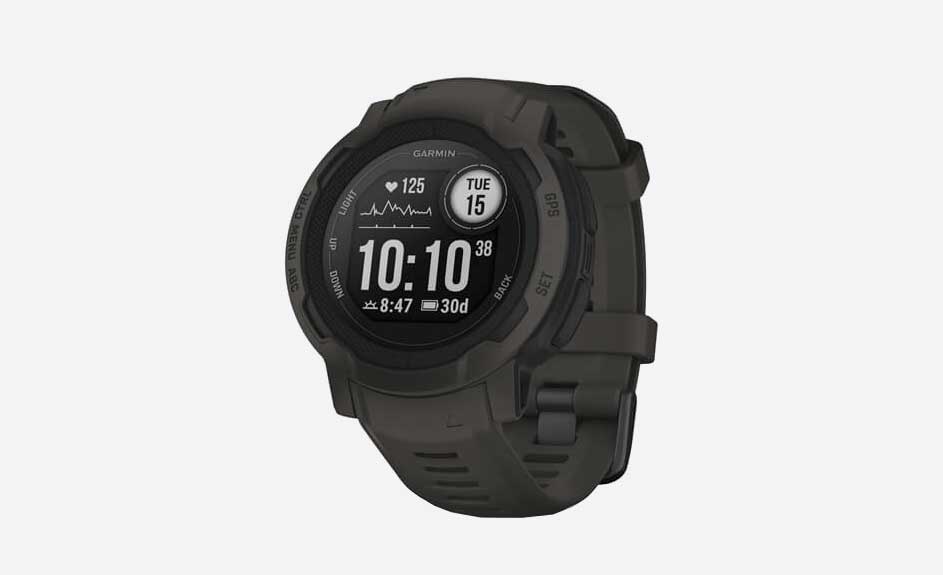 Montre numérique brune sur fond blanc affichant l'heure 10:10, la date, le rythme cardiaque et d'autres données.